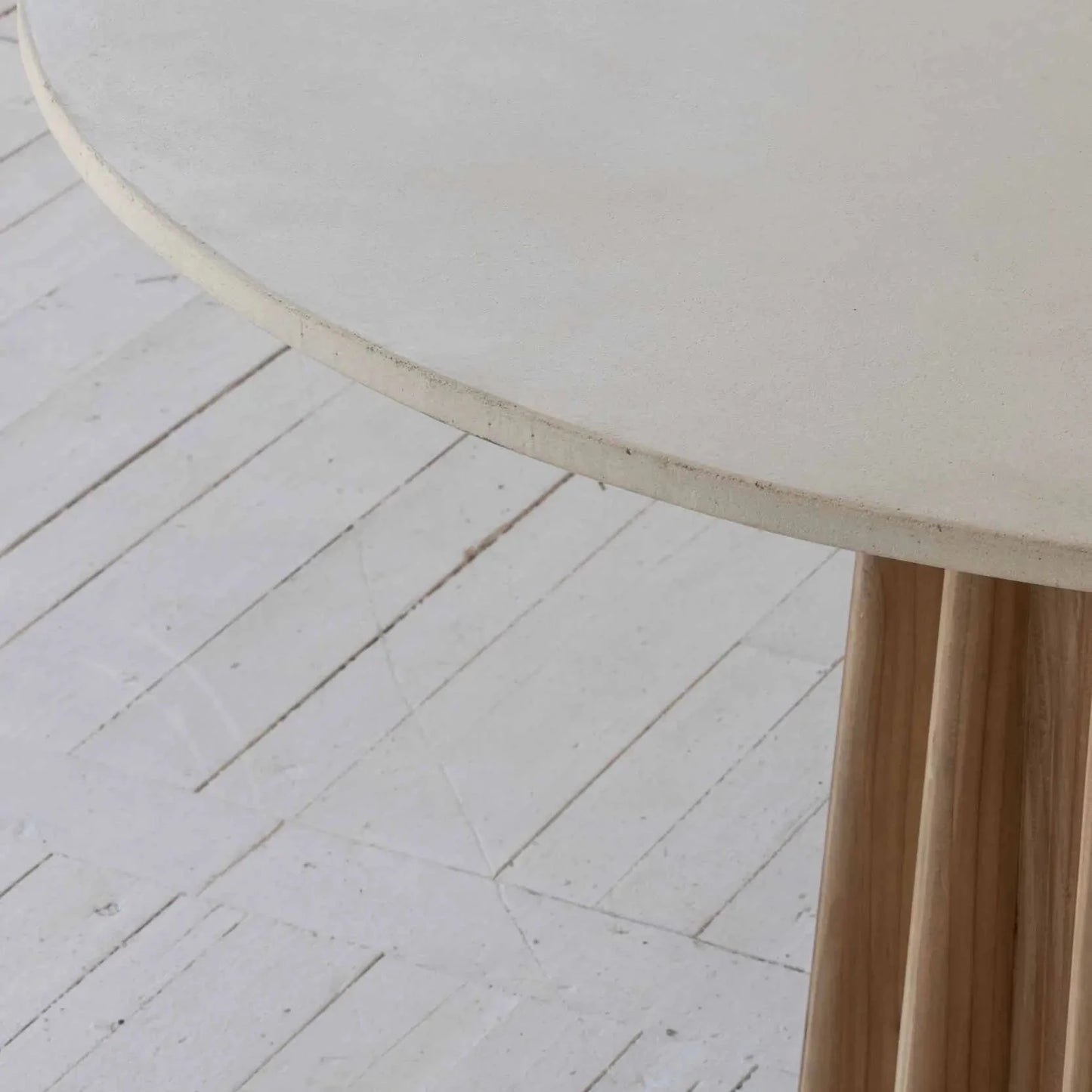 Round dining table with concrete table top finished in white, supported by a pine wood corrugated base. Available to purchase from Albury House Interiors.