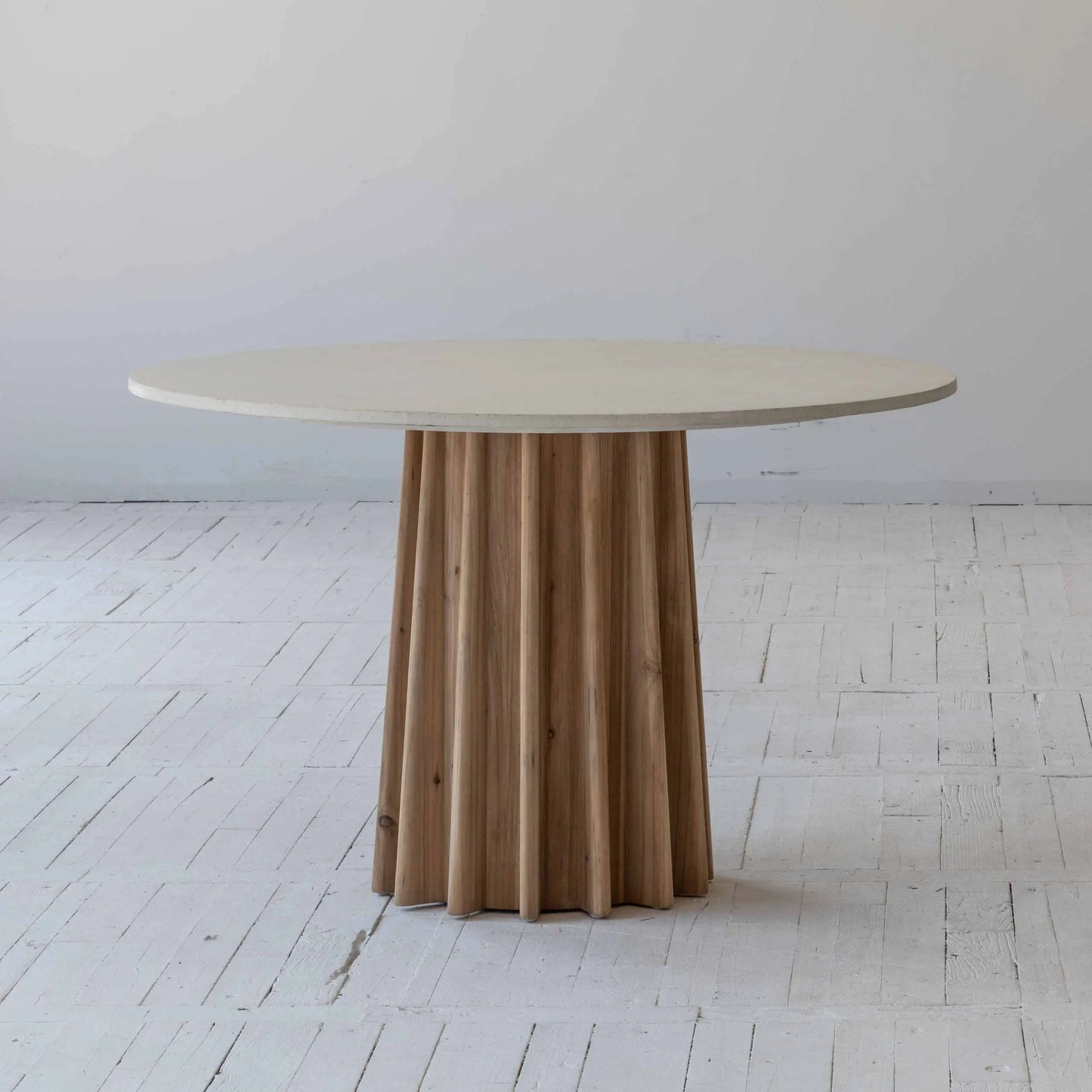 Round dining table with concrete table top finished in white, supported by a pine wood corrugated base. Available to purchase from Albury House Interiors.