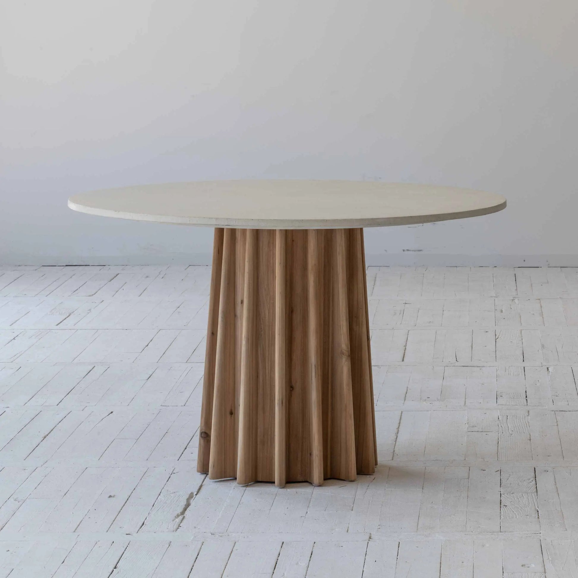 Round dining table with concrete table top finished in white, supported by a pine wood corrugated base. Available to purchase from Albury House Interiors.