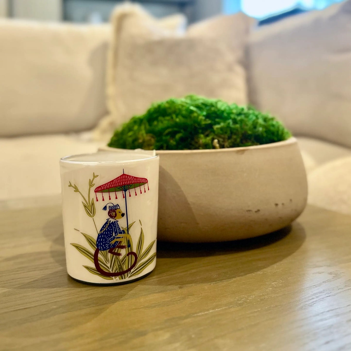 pomegranate-noir-scented-candle-in-glass-jar-with-monkey-umbrella-featured-on-the-front-in-gift-box-at-albury-house-interiors