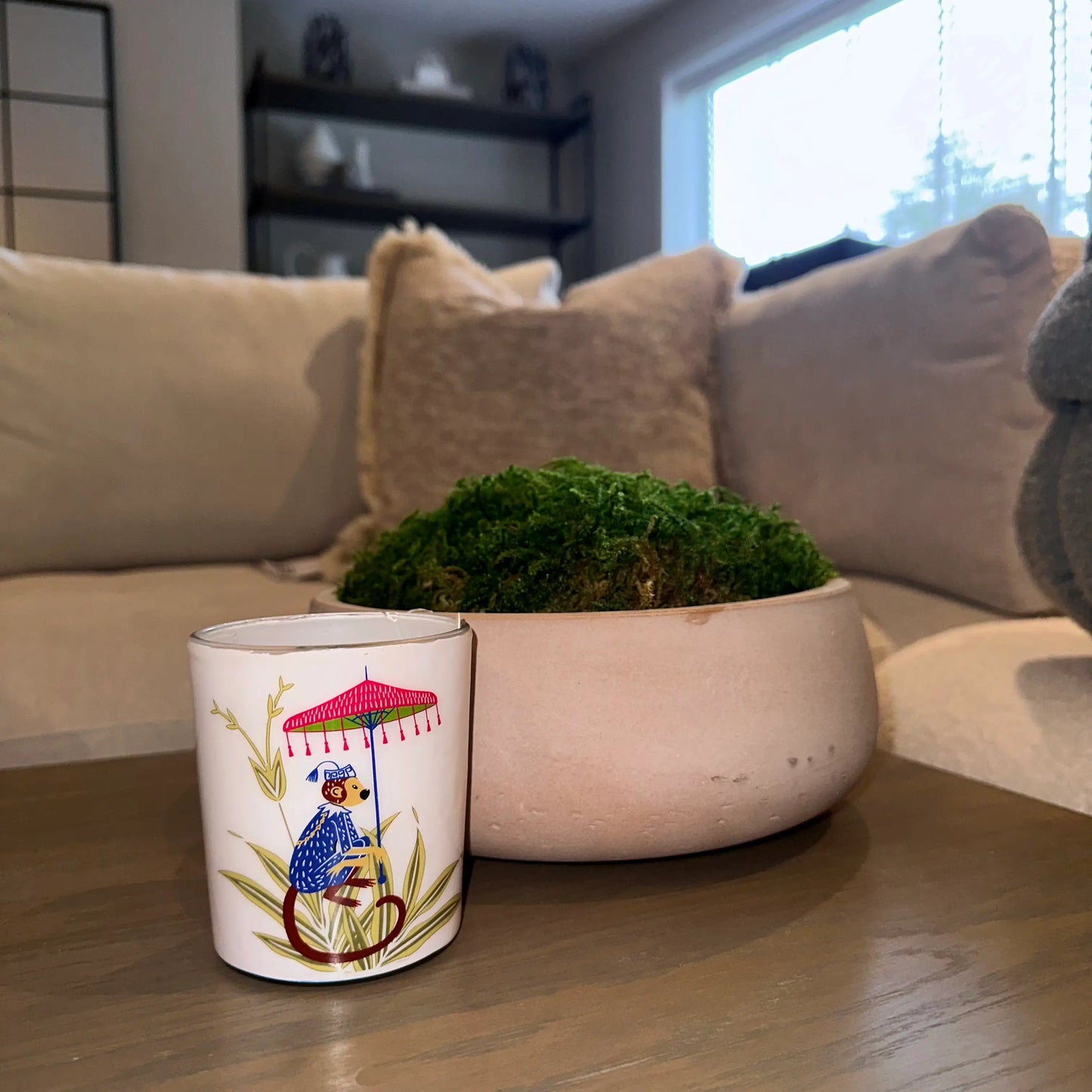 pomegranate-noir-scented-candle-in-glass-jar-with-monkey-umbrella-featured-on-the-front-in-gift-box-at-albury-house-interiors