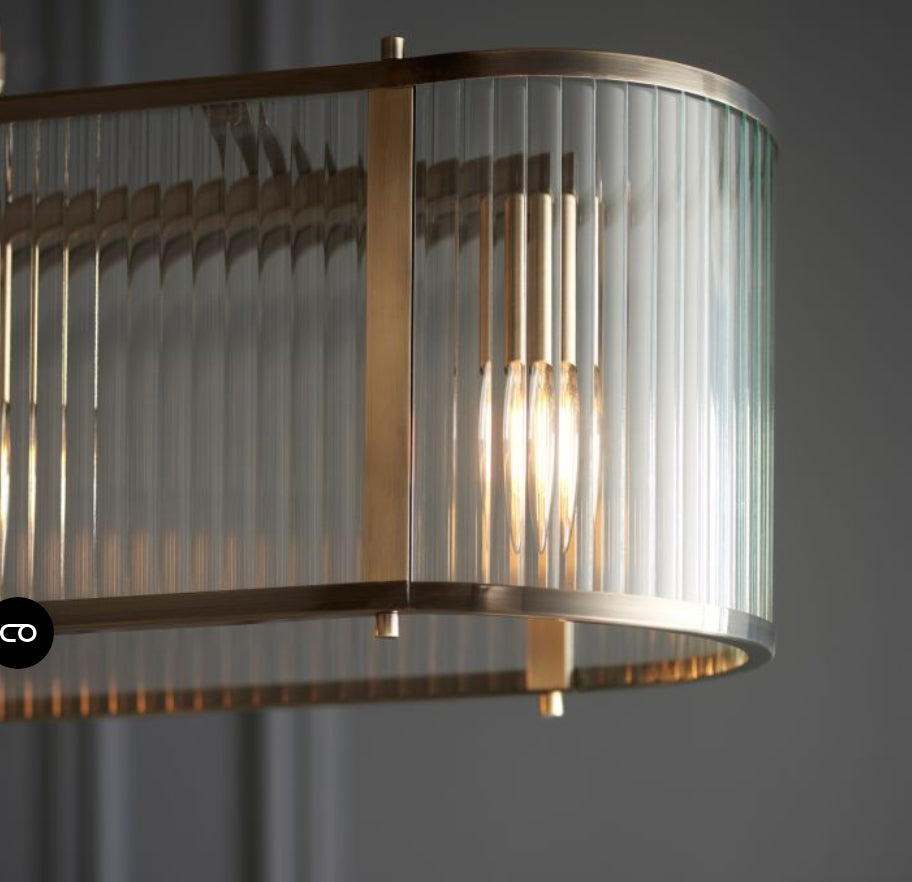 Chandelier with brass frame and ribbed, clear glass panels hanging from a chain