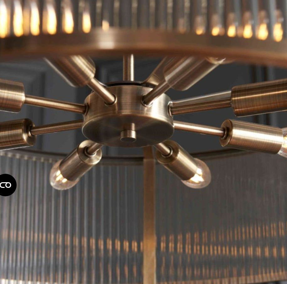 Ribbed glass, brass chandelier light with multiple arms against a dark background
