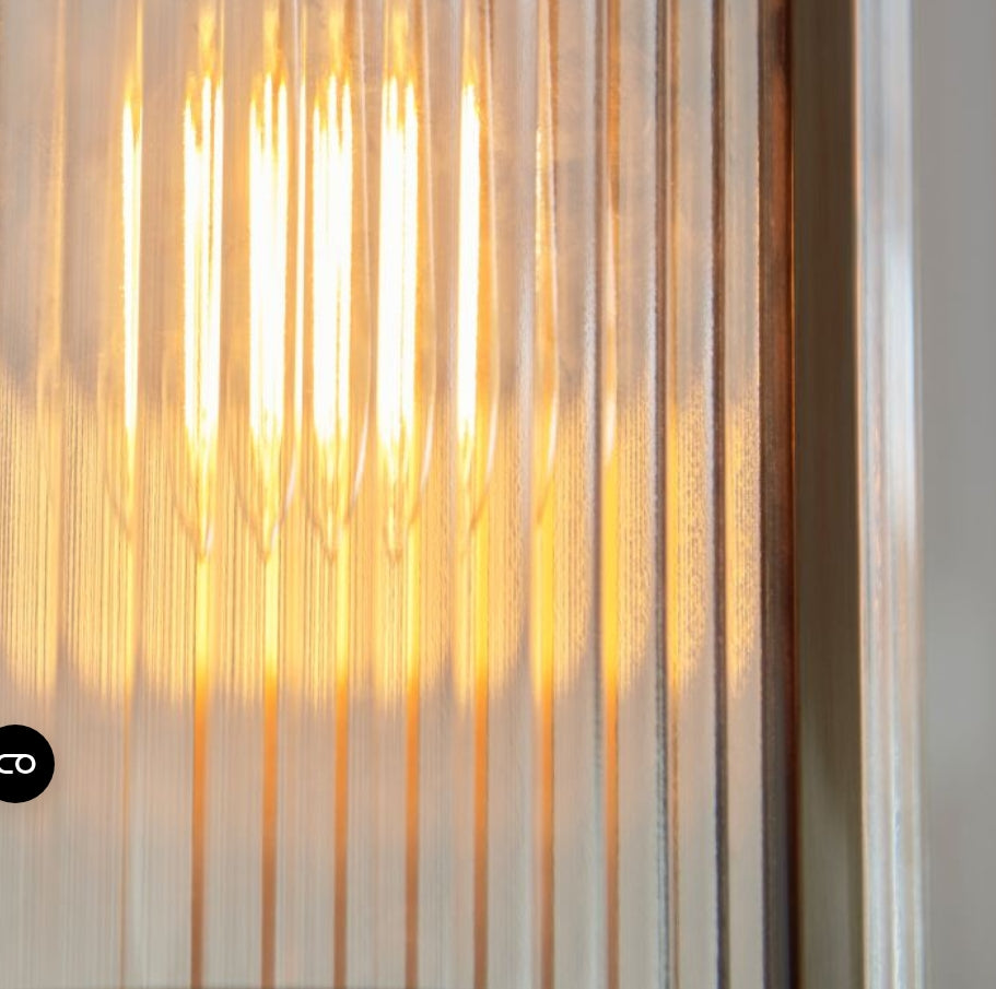 Pendant brass metal light with ribbed glass shade hung on a chain, close up