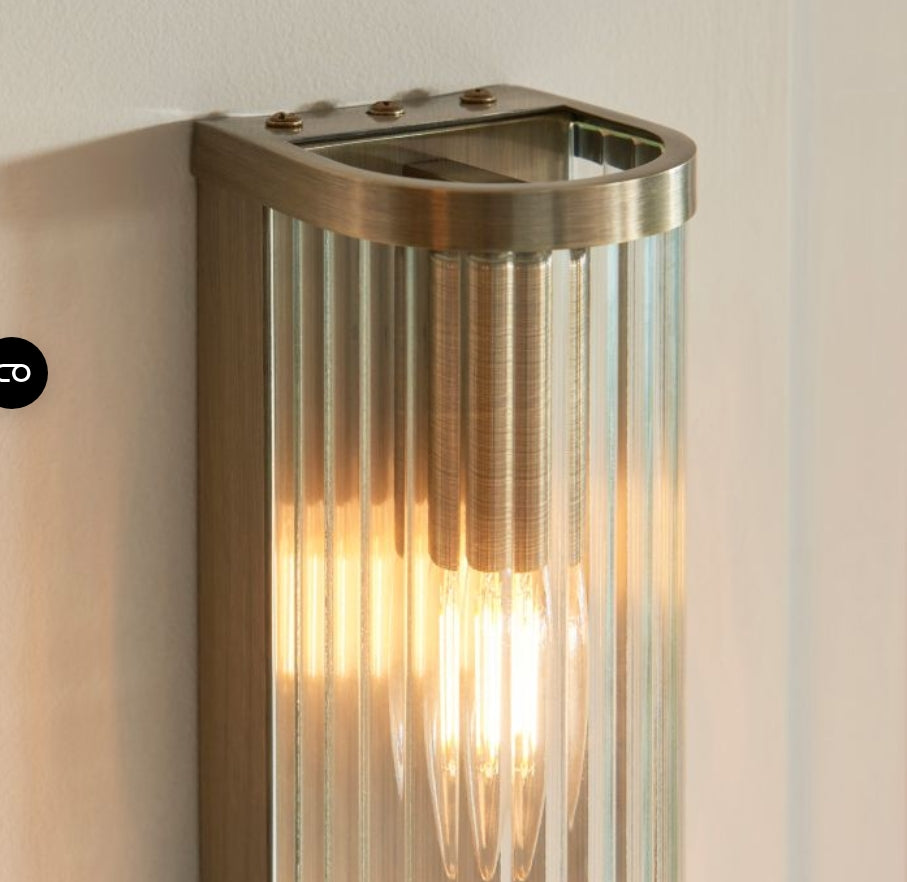 Tall cylindrical wall light fixture with ribbed glass and brass fixtures. Available to purchase from Albury House Interiors. 