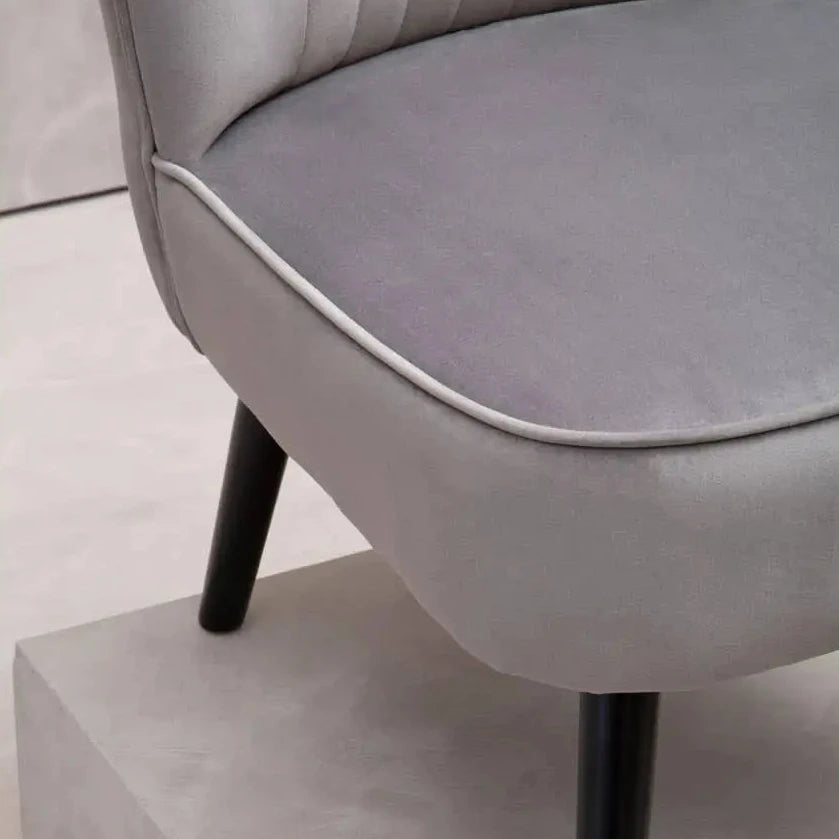 Sorrento grey velvet occasional chair with matching grey piped edges and pleated detail back, finished with black wooden legs. Available at Albury House Interiors.