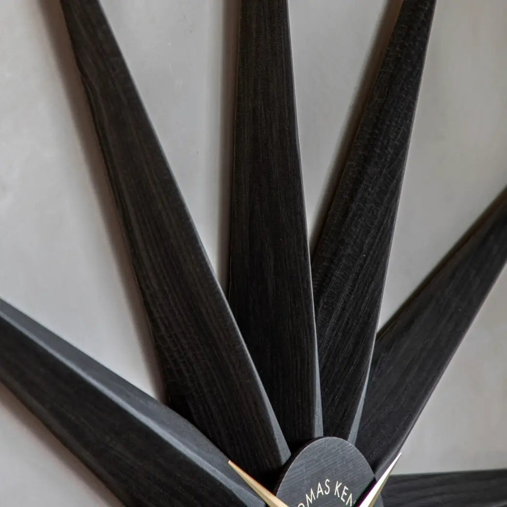 Starburst statement wall clock in North Star shape crafted from wood and finished in a dark warm grey, with gold accents and matching clock hands. Available to purchase from Albury House Interiors, home decor and accessories shop in Essex. 