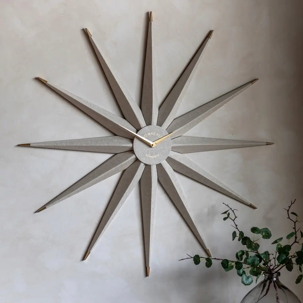 Starburst wooden statement wall clock crafted from wood shaped like the North Star. Accents of gold and matching gold clock hands, available to purchase at Albury House Interiors.