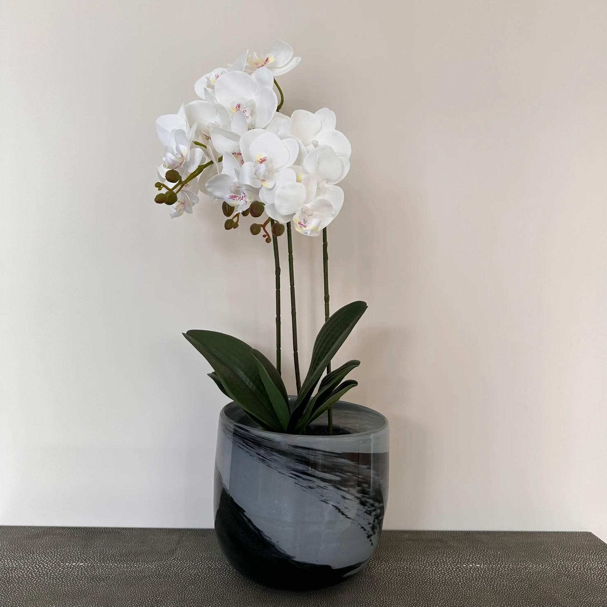 Black and grey glass swirl planter with faux orchid, perfect for faux flowers, real plants and fresh flowers. Available to purchase at Albury House Interiors, homewares and home decor shop in Essex. 