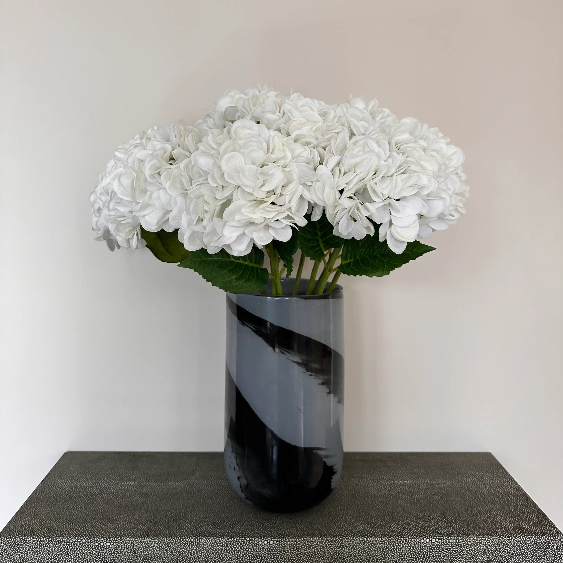 Black and grey glass swirl vase size small with white hydrangeas, perfect for faux flowers, real plants and fresh flowers. Available to purchase at Albury House Interiors, homewares and home decor shop in Essex. 