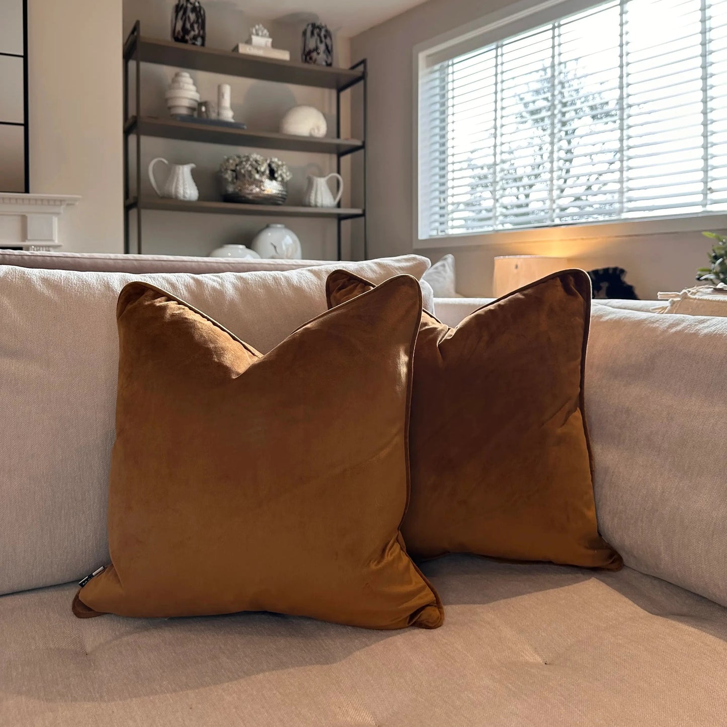 tan-orange-velvet-square-shaped-piped-edge-cushions-with-feather-inserts-on-beige-bespoke-sofa-at-albury-house-interiors