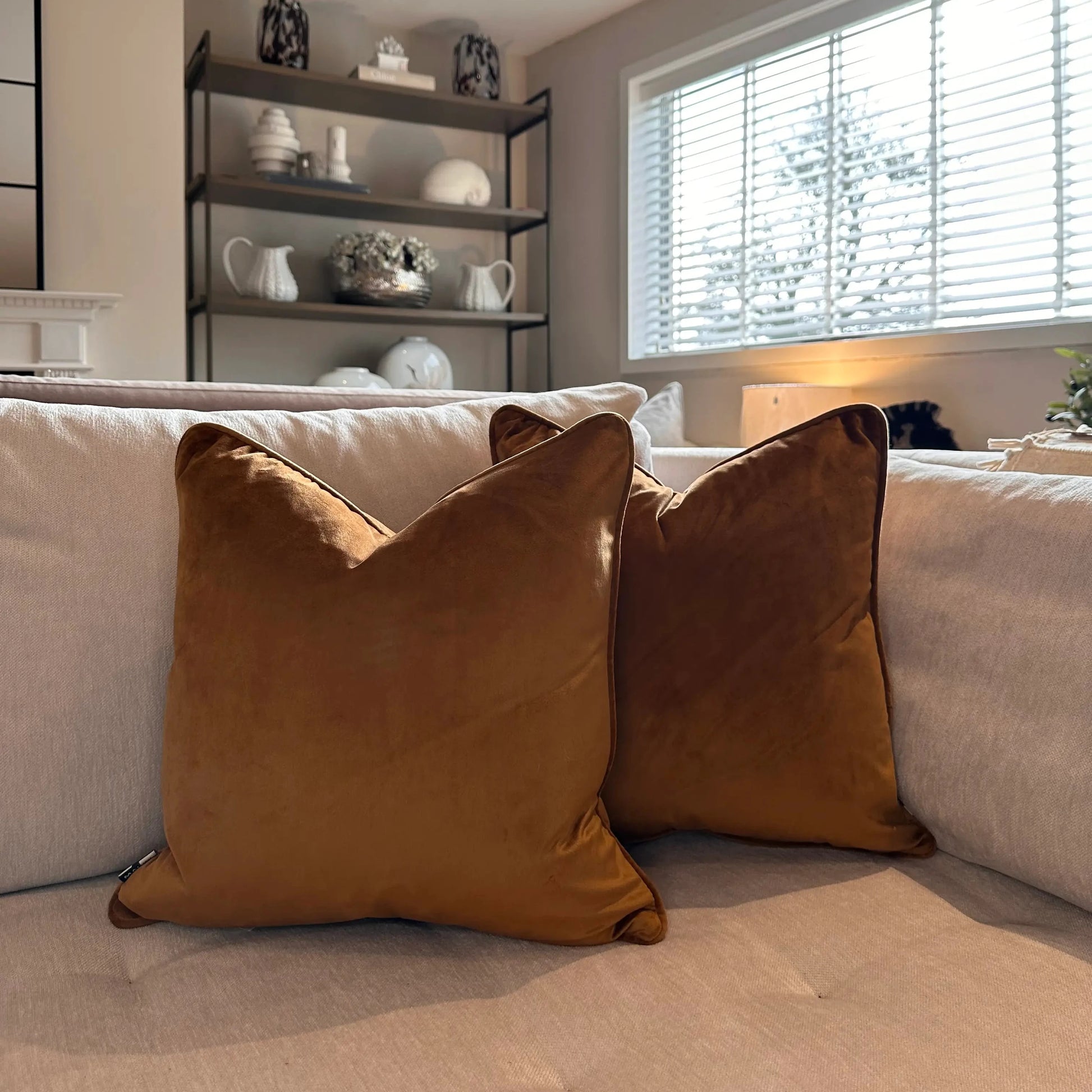 tan-orange-velvet-square-shaped-piped-edge-cushions-with-feather-inserts-on-beige-bespoke-sofa-at-albury-house-interiors