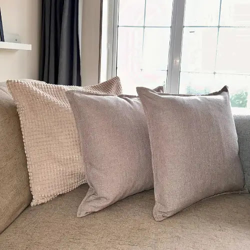 Taupe linen square cushions with matching piping, complete with feather filled insert, available to buy at Albury House Interiors. 