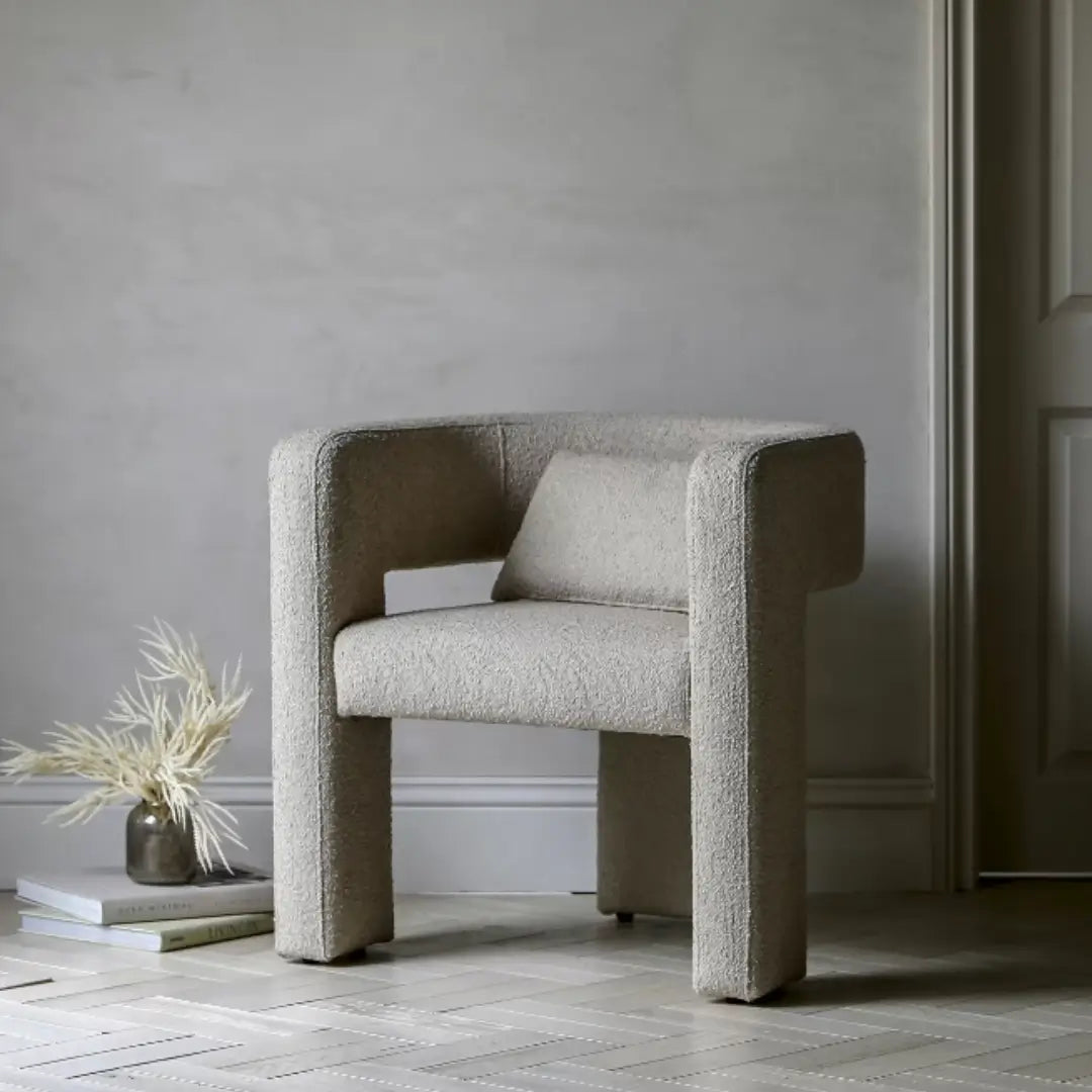 Torrent curved tub chair with three wide legs, upholstered in a beautiful neutral boucle material with matching bolster cushion. Perfect to use as dining chairs or occasional chairs in bedrooms or living rooms. Available to purchase from Albury House Interiors. 