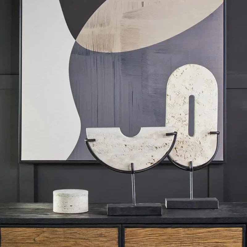 Natural travertine stone oval shaped and half moon shaped disc displayed on matte black stands, used by interior designers. Available to purchase from Albury House Interiors. 