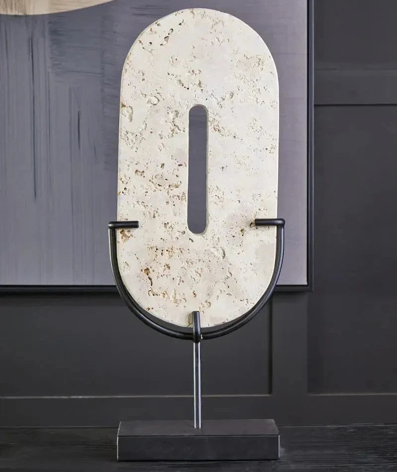 Natural travertine stone oval shaped disc displayed on matte black stand, used by interior designers. Available to purchase from Albury House Interiors. 