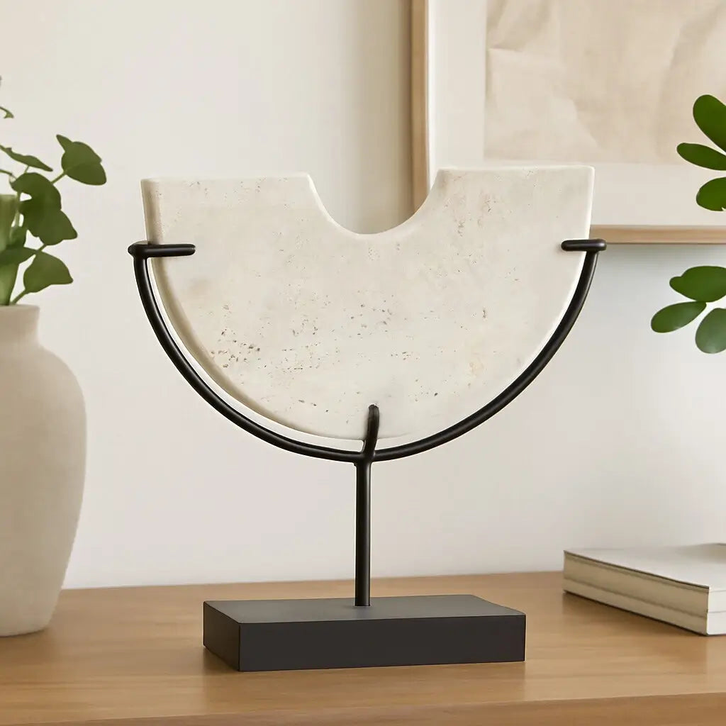 Natural travertine stone crafted into a half moon semi-circle shape, displayed on a matte black stand. Used by interior designers and home stylists. Available to purchase at Albury House Interiors. 