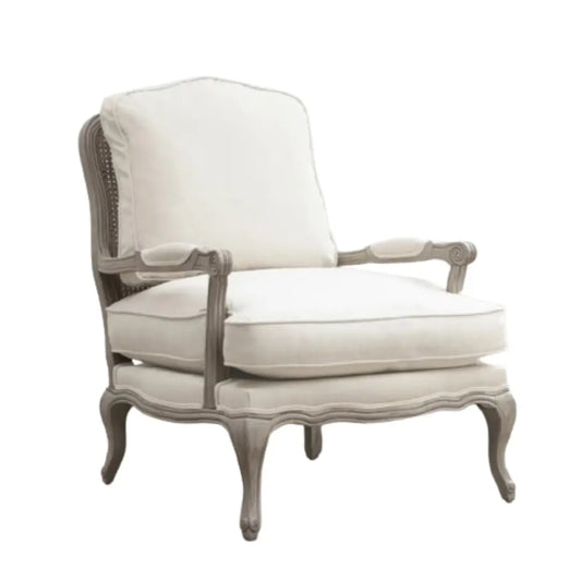 Valais solid oak frame armchair stained in a stone grey with distressed finish. Seat and back cushion upholstered in cream linen with matching armrest padding. Complete with grey rattan back. Available in oak and stone at Albury House Interiors.