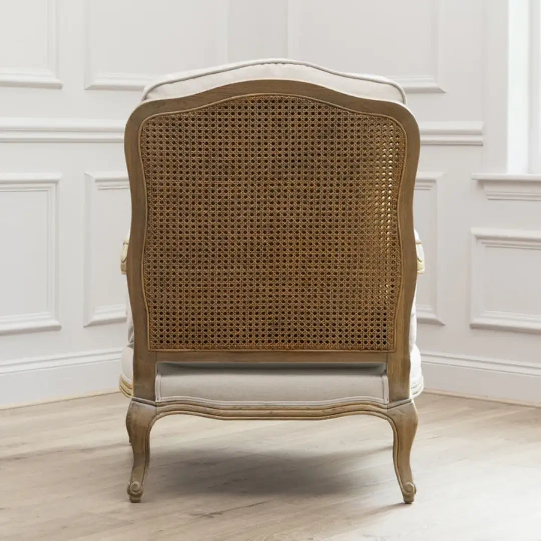 Valais arm chair crafted rom solid oak with rattan back. Cream linen upholstered seat and backrest cushion, with matching armrest padding. Available to purchase from Albury House Interiors in two colours.