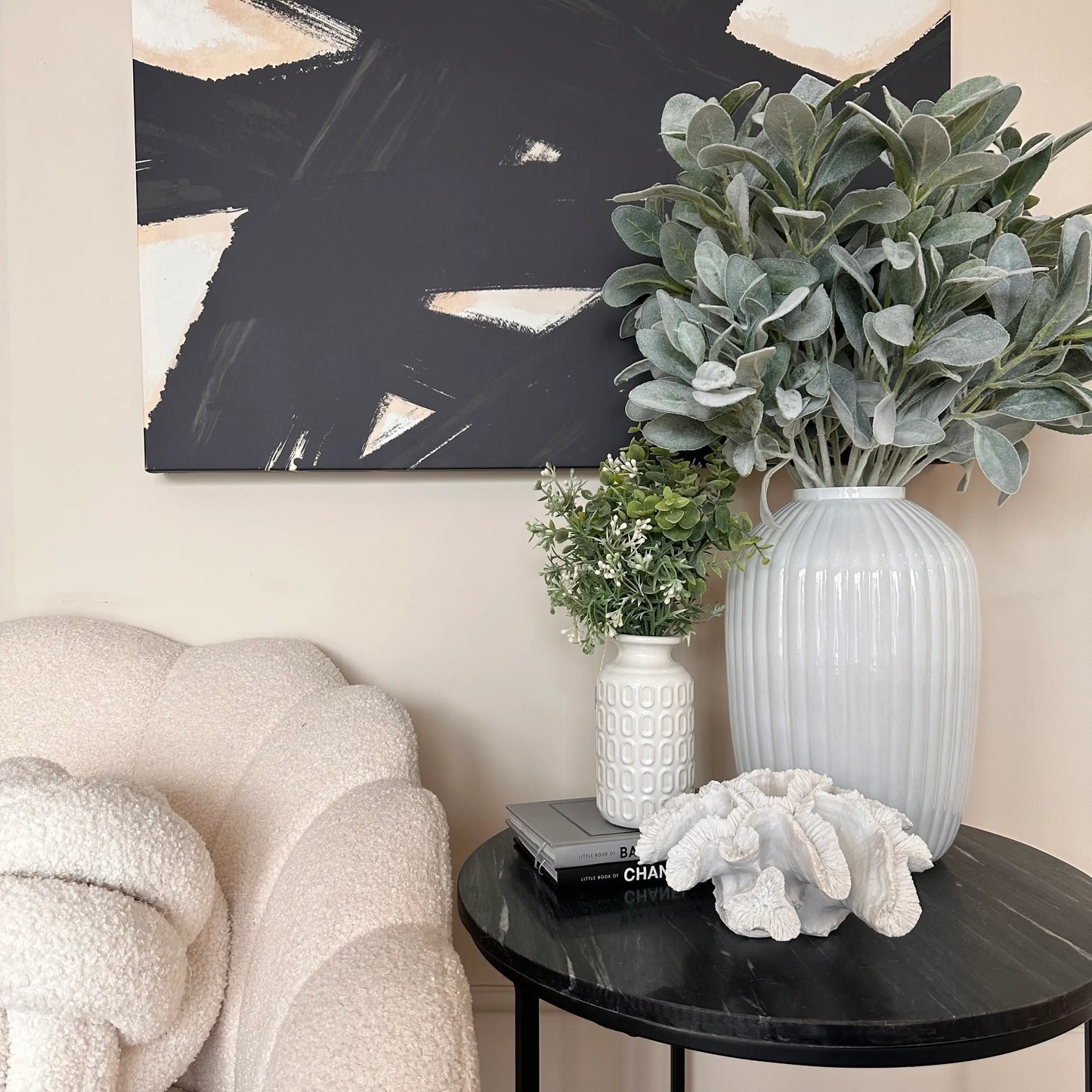 black-marble-round-side-table-displaying-white-glass-ribbed-vase-with-faux-lambs-ear-large-faux-white-coral-and-white-retro-vase-with-faux-foiliage-at-albury-house-interiors-shop-essex