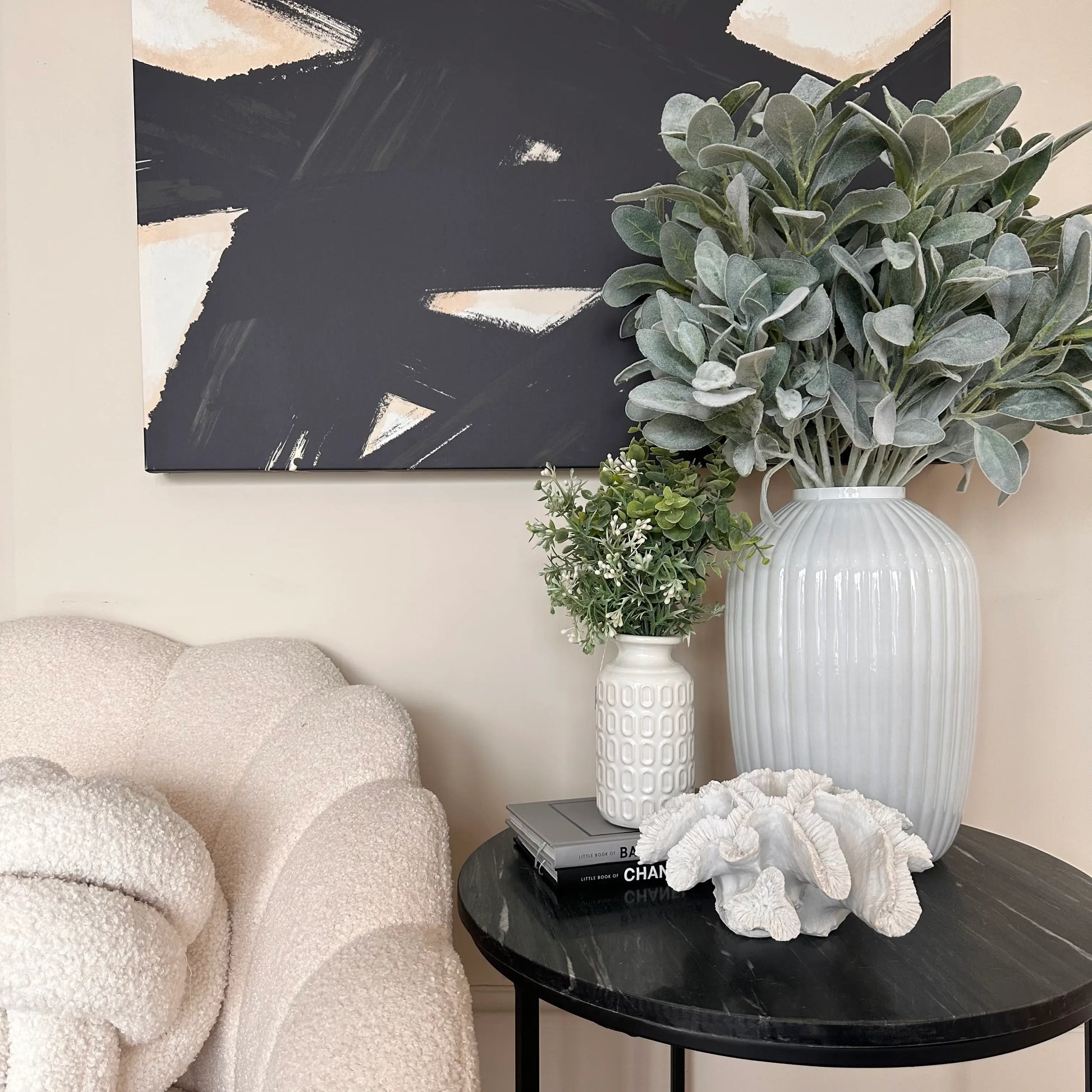 black-marble-round-side-table-displaying-white-glass-ribbed-vase-with-faux-lambs-ear-large-faux-white-coral-and-white-retro-vase-with-faux-foiliage-at-albury-house-interiors-shop-essex