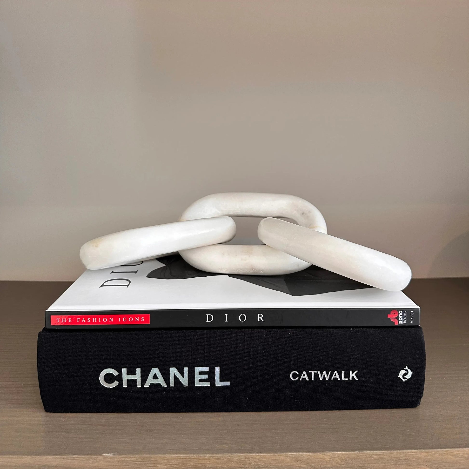 natural-white-marble-chain-link-sculpture-on-stack-of-designer-books-at-albury-house-interiors