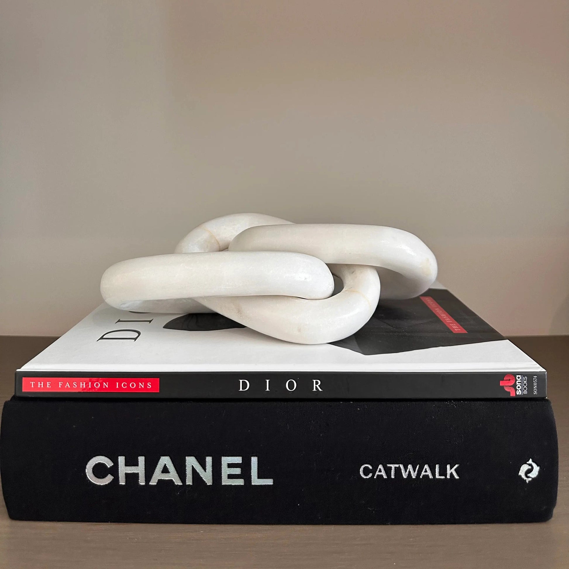 natural-white-marble-chain-link-sculpture-on-stack-of-designer-books-at-albury-house-interiors