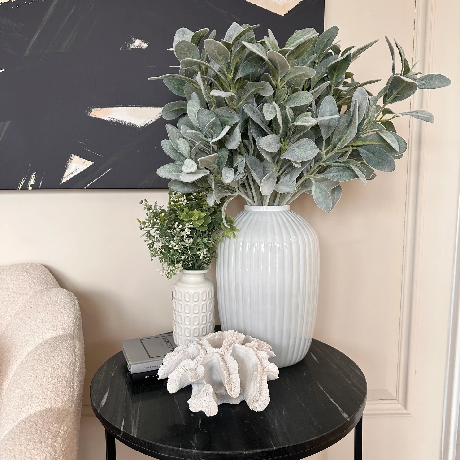 black-marble-round-side-table-displaying-white-glass-ribbed-vase-with-faux-lambs-ear-large-faux-white-coral-and-white-retro-vase-with-faux-foiliage-at-albury-house-interiors-shop-essex