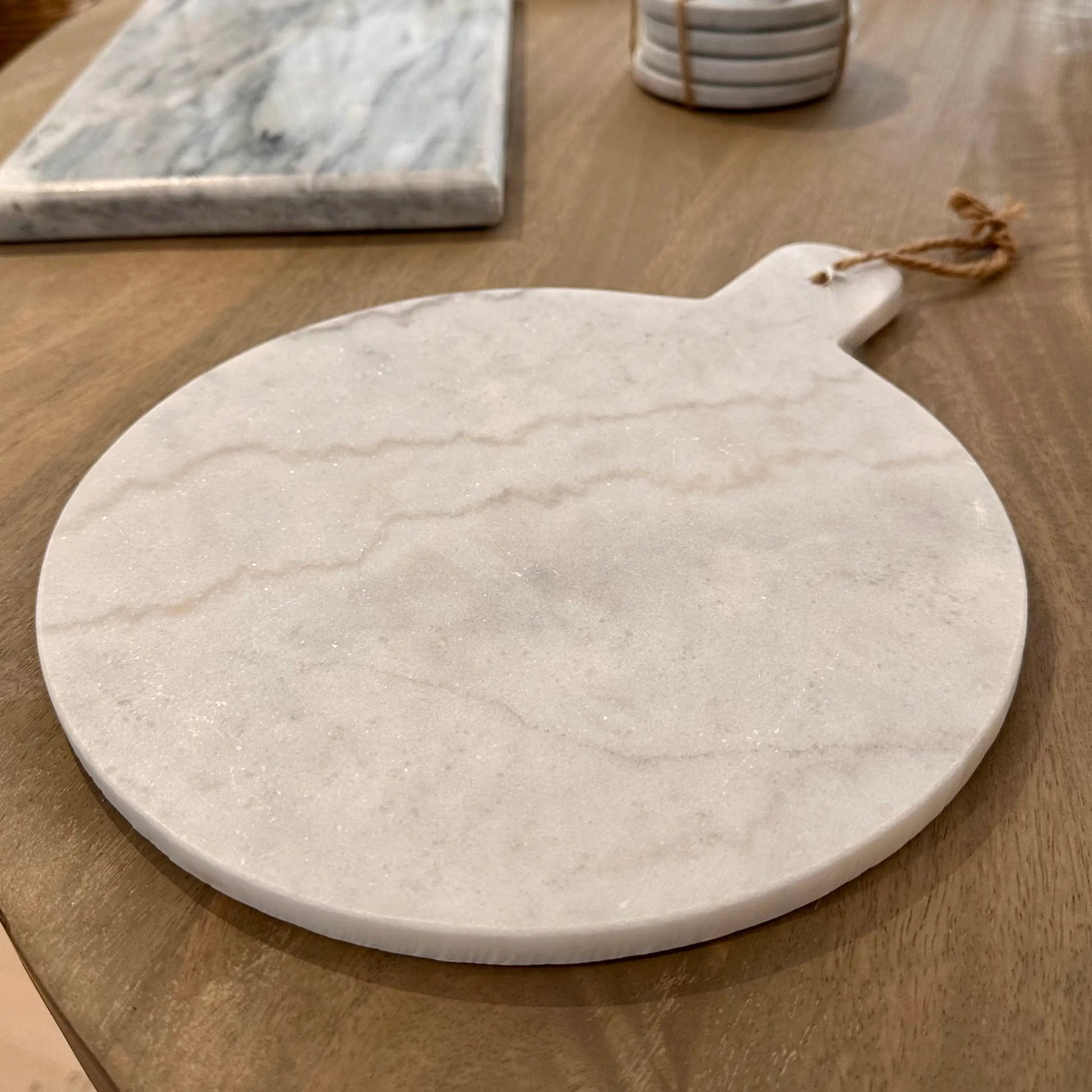 White natural marble round chopping and serving board, both functional and stylish. Comes complete with a string to hang and display. Available to purchase from Albury House Interiors. 