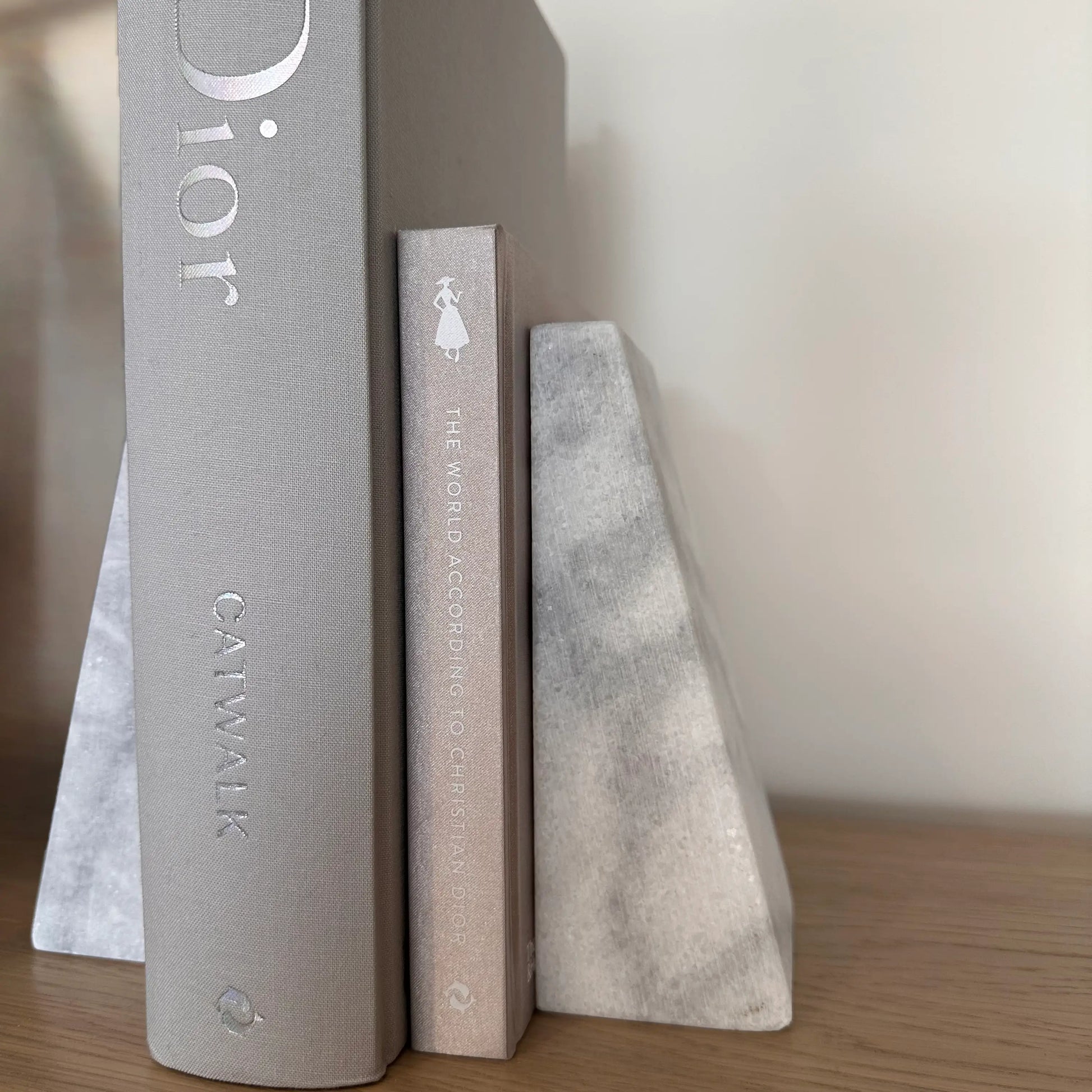 white-and-grey-veined-natural-marble-stone-bookends-with-grey-dior-designer-coffee-table-books-at-albury-house-interiors